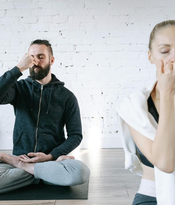 Pregnant woman in a serene yoga pose in a bright, calm room.