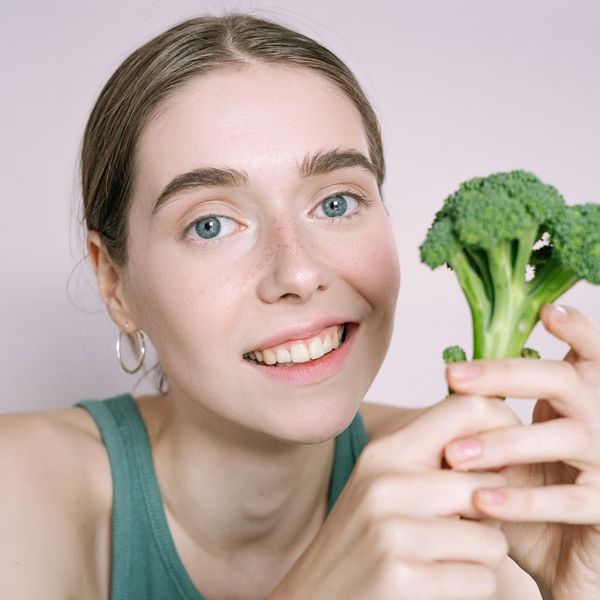Woman smiling peacefully with eyes closed after a wellness session.